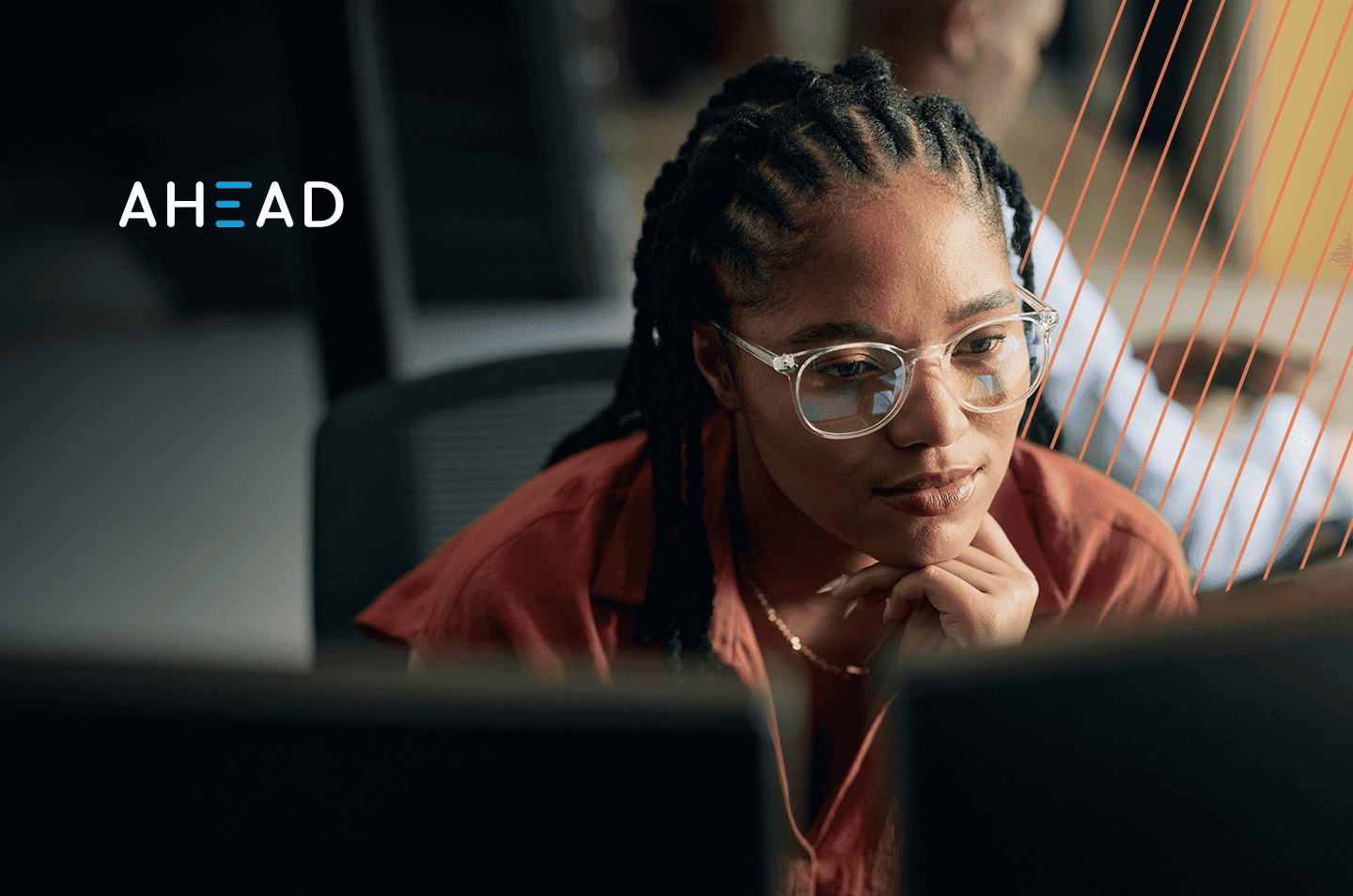A woman sitting in front of computer monitors