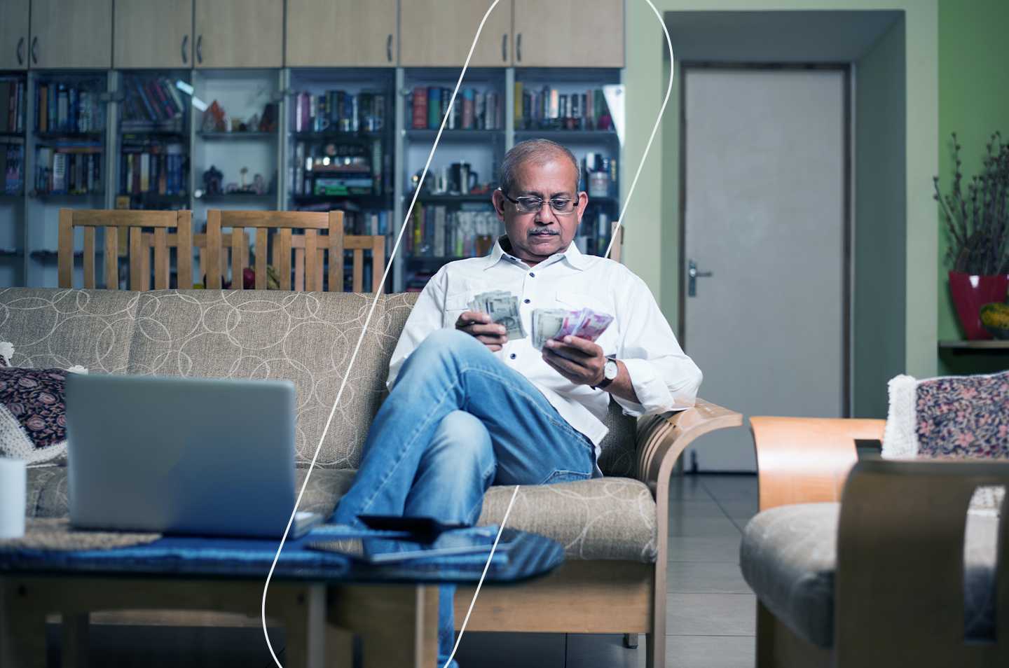 man sitting on a couch counting paper money