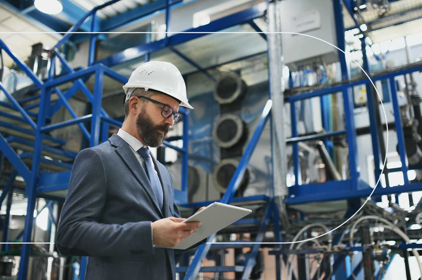 man standing in a workspace looking at a clipboard