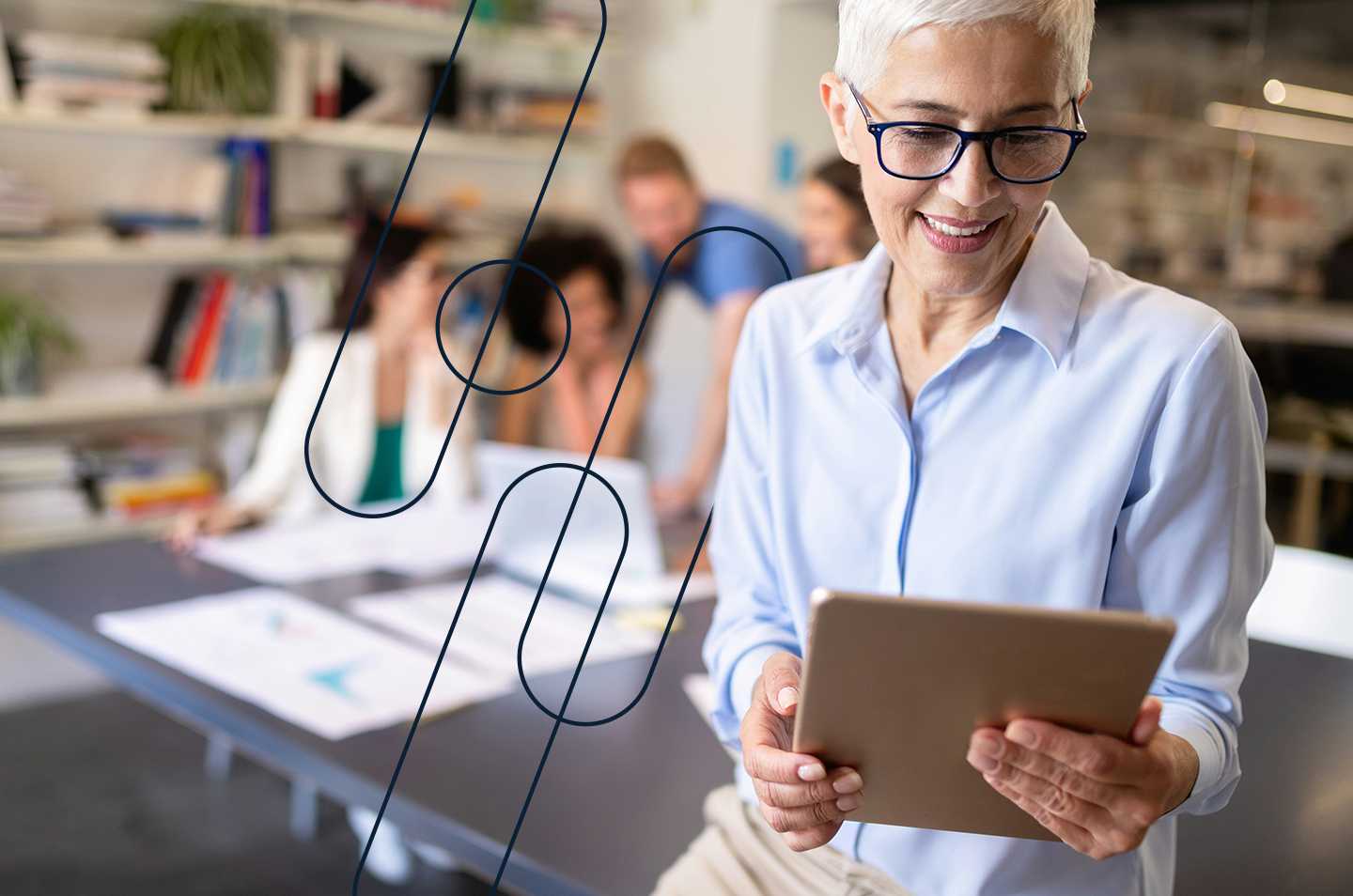 A woman in the foreground holding a tablet with people in the background