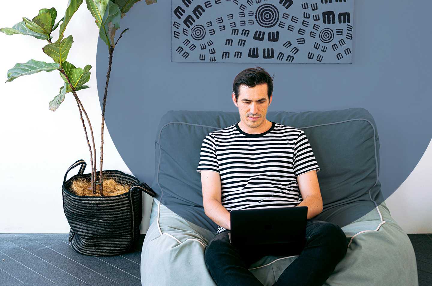 man sitting on a chair working on a laptop