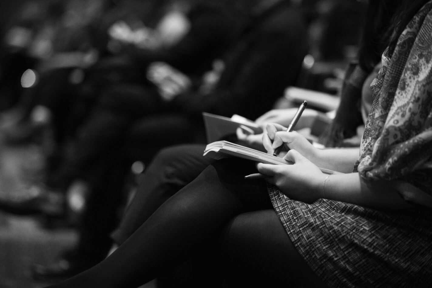 black and white photo of people sitting in an audience